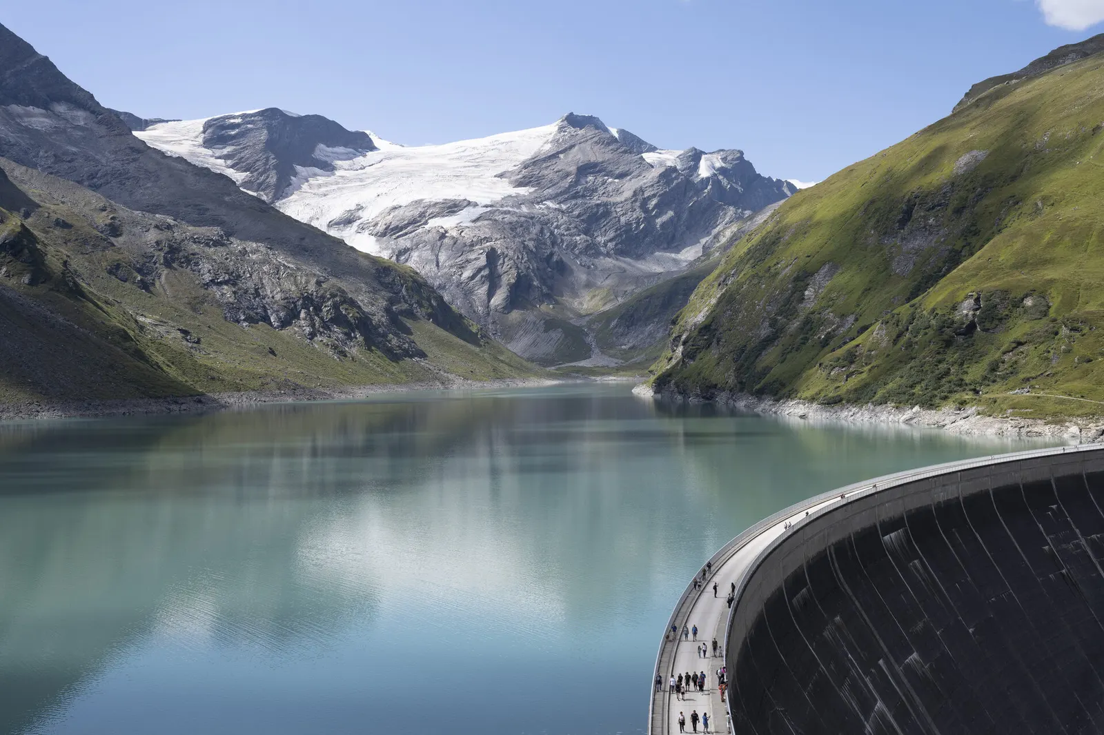 Stausee Mooserboden in Kaprun: Blick über die Staumauer auf den türkisgrünen See und schneebedeckte Berge